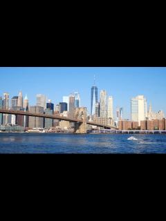 [x]街につながる橋で川を渡るボートのローアングル映像：無料の動画素材